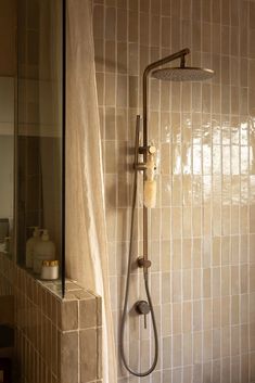 a shower head and hand held shower faucet in a bathroom with tiled walls