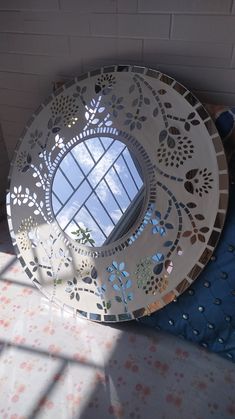 a round mirror sitting on top of a table next to a window in a room