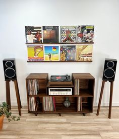 an entertainment center with speakers, record players and records on the wall in front of it