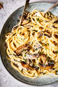 pasta with mushrooms and parmesan cheese in a bowl on a marble table top