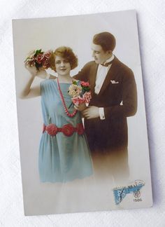 an old photo of a man and woman holding flowers