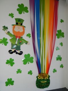 a st patrick's day decoration with rainbow streamers and shamrocks on the wall