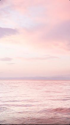 two surfers walking into the ocean at sunset