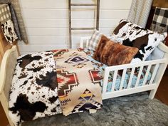 a bed with two pillows on top of it and a ladder in the back ground