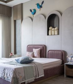 a bed room with a neatly made bed and two birds on the wall above it