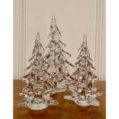 three crystal christmas trees sitting on top of a wooden table