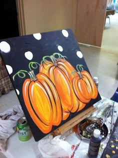 an easel with some pumpkins painted on it