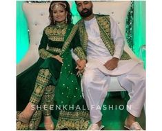 a man and woman dressed in green sitting on a white couch