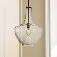 a glass light fixture hanging from a ceiling in a room with white walls and windows