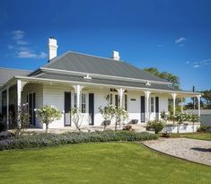 a white house sitting on top of a lush green field