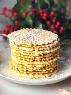 a stack of crackers sitting on top of a white plate next to red berries