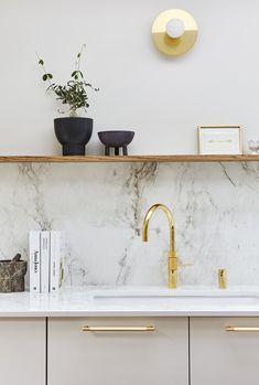 an instagramted photo of a kitchen counter with gold faucets