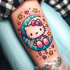 a hello kitty tattoo on the right arm and leg, with stars around her neck