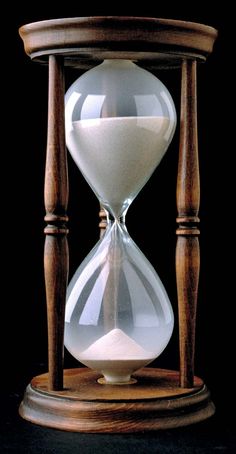 an hourglass sitting on top of a wooden stand