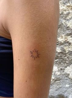 a woman with a small sun tattoo on her arm