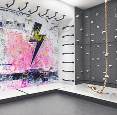 an abstract painting on display in a room with ropes and hooks hanging from the ceiling