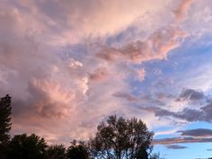 the clouds are pink and blue as the sun sets