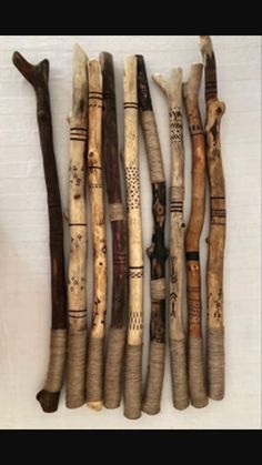 several wooden sticks are hanging on the wall next to each other, with different patterns and shapes