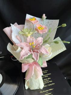 a bouquet of flowers sitting on top of a record