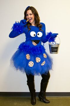 a woman in a cookie monster costume poses for the camera while holding a bucket with cookies on it