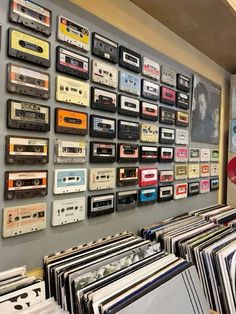 there is a wall full of cassettes and records on the wall in this room