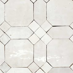 a white tiled floor with hexagonal tiles on it's sides and the top half missing