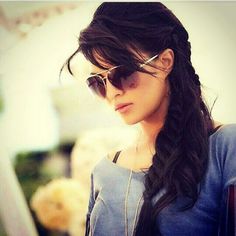 a woman with long black hair and sunglasses