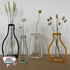 three vases with flowers in them sitting on a table