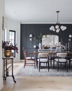 a dining room table and chairs in front of a mirror