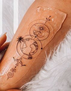 a woman with a tattoo on her leg that has the earth and stars in it