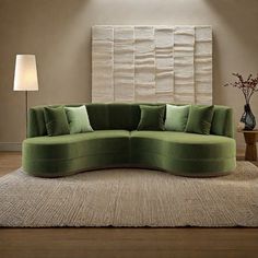 a green couch sitting on top of a rug in a living room next to a lamp