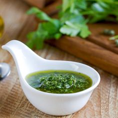 a small white gravy dish filled with pesto sauce and garnished with parsley