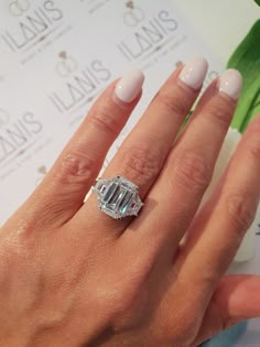 a woman's hand with a diamond ring on it