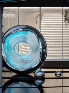 a glass sculpture sitting on top of a table next to a window with shutters