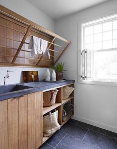 a kitchen with wooden cabinets and blue counter tops next to a white sink in front of a window