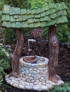 a miniature garden with trees and rocks in it's center, including a potted plant