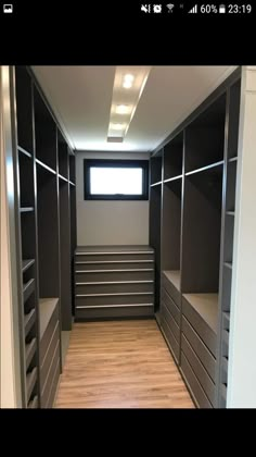 an empty walk in closet with drawers and shelves