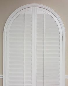 an arched window with white shutters in the middle and side panels on each side