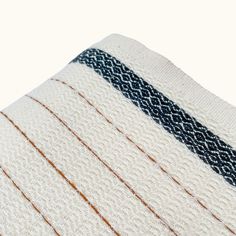 a white towel with blue and orange stripes on it's side, folded in half