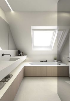 a white bathroom with a skylight above the bathtub and sink, is shown in this image