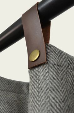 a close up of a coat hanger with a leather button on it's end