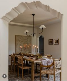 the dining room table is set with place settings for six people and has candles on it