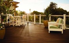 a deck with chairs and potted plants on it