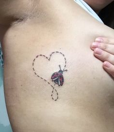 a ladybug tattoo on the side of a woman's stomach is shown