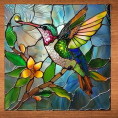 a stained glass hummingbird sitting on a tree branch