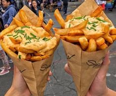 two people holding up some food in their hands