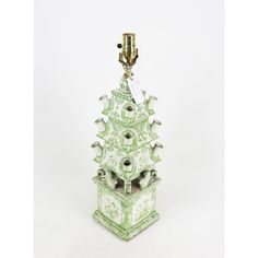 a green and white birdhouse with a gold top