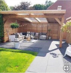 an outdoor patio area with wooden pergolan and white furniture in the back yard