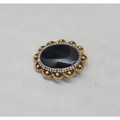 Circa 1980s goldtone oval smooth faux-onyx center with tiny round clear rhinestones surround brooch with security clasp and loop to be worn as a pendant. Measures: 1 3/8 inches long by 1 1/8 inches wide. Condition: Very good; a few of the tiny clear rhinestones have darkened, but they're so small it's not very noticeable. Gold Oval Brooch For Evening, Antique Oval Brooches For Evening, Elegant Oval Cabochon Brooch Jewelry, Formal Round Costume Jewelry Brooches, Oval Costume Jewelry Brooch, Oval Brooches For Evening, Elegant Oval Brooch For Evening, Oval Evening Brooches, Elegant Oval Brooches For Evening