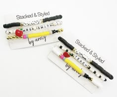 three bracelets with black, white and yellow beads are on top of each other